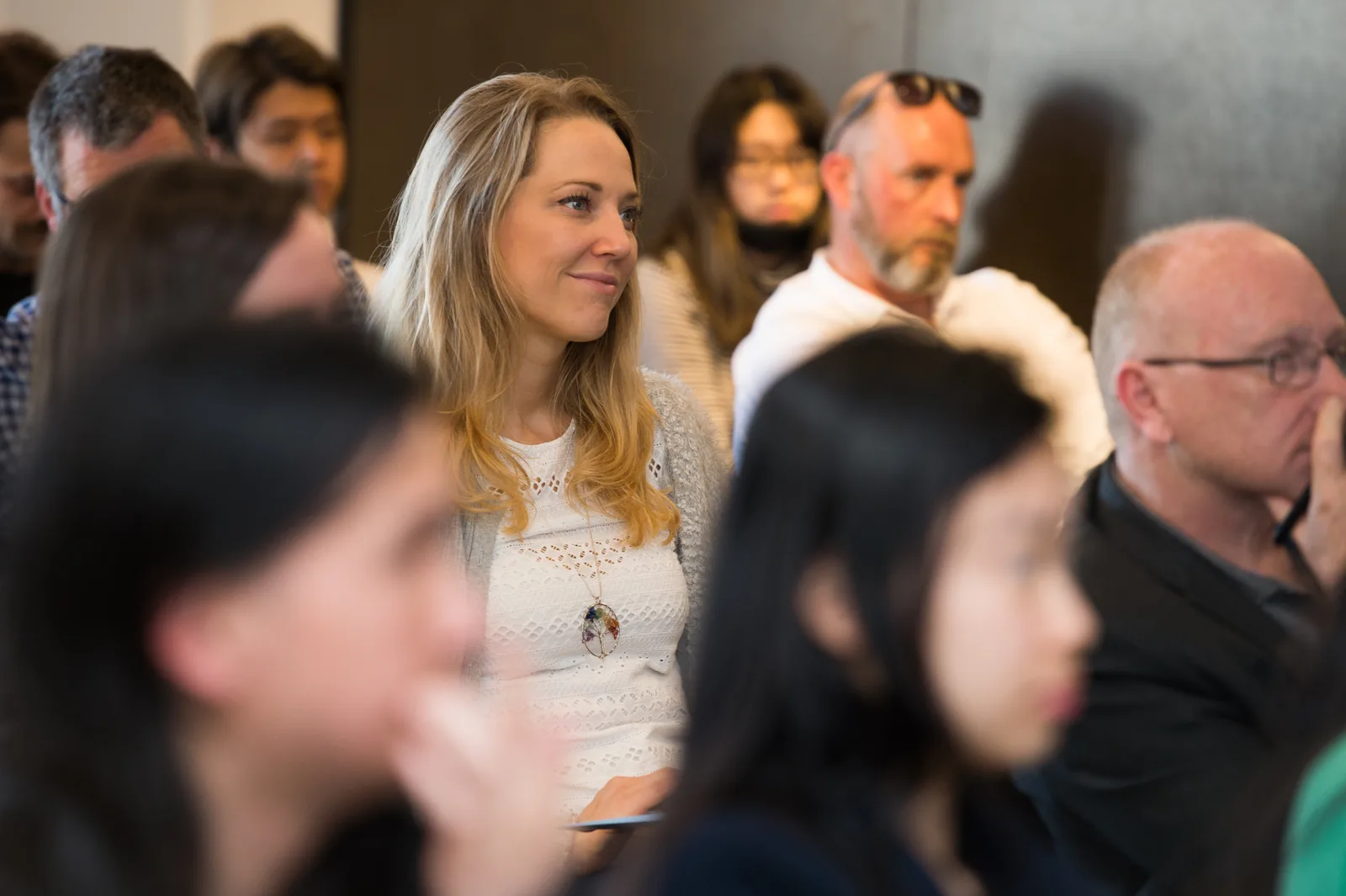 A business owner smiling in the crowd at a 25eight workshop